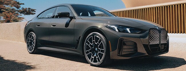 BMW i4 M50 parked near contemporary architecture, showcasing its aerodynamic Gran Coupe design