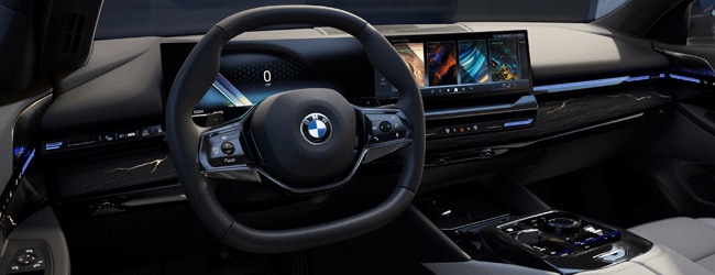 BMW interior featuring curved digital display, ambient lighting, and minimalist modern dashboard design