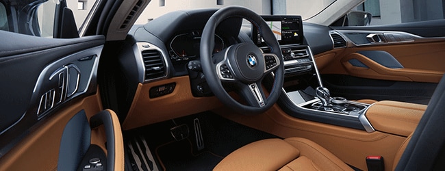 Driver-focused BMW interior with bold orange leather upholstery and high-tech center stack