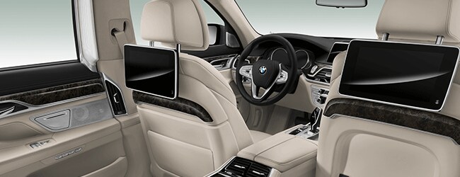 Rear entertainment screens and premium beige leather interior inside a BMW 7 Series