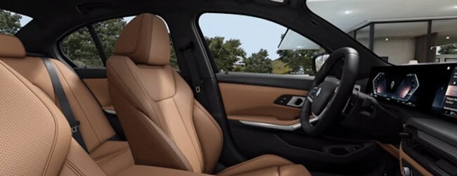 Interior of 2025 BMW 3 Series showing view from passenger seat of drivers cockpit area with black and tan leather upholstery