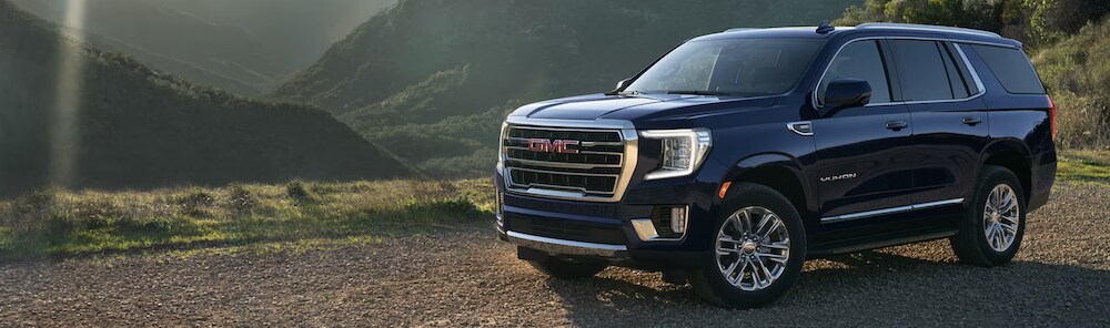 2023 GMC Acadia 2023 GMC Yukon XL parked on dirt road