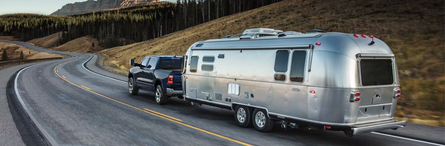 Rear view of the 2024 RAM 1500 towing a trailer Rear view of the 2024 RAM 1500 towing a trailer