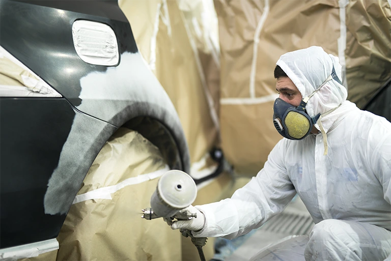 TommyCar Collision Center near me, in Northampton, MA Auto body service technician spray painting vehicle