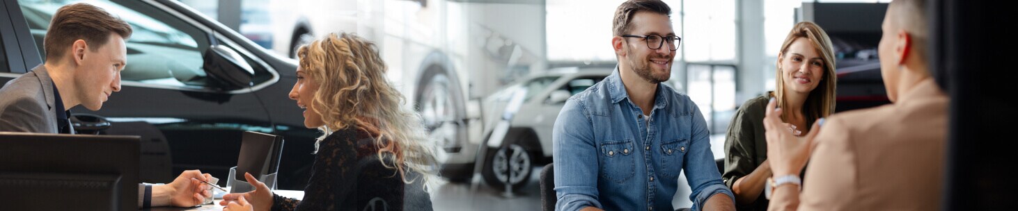 Salespeople assist families in auto financing.