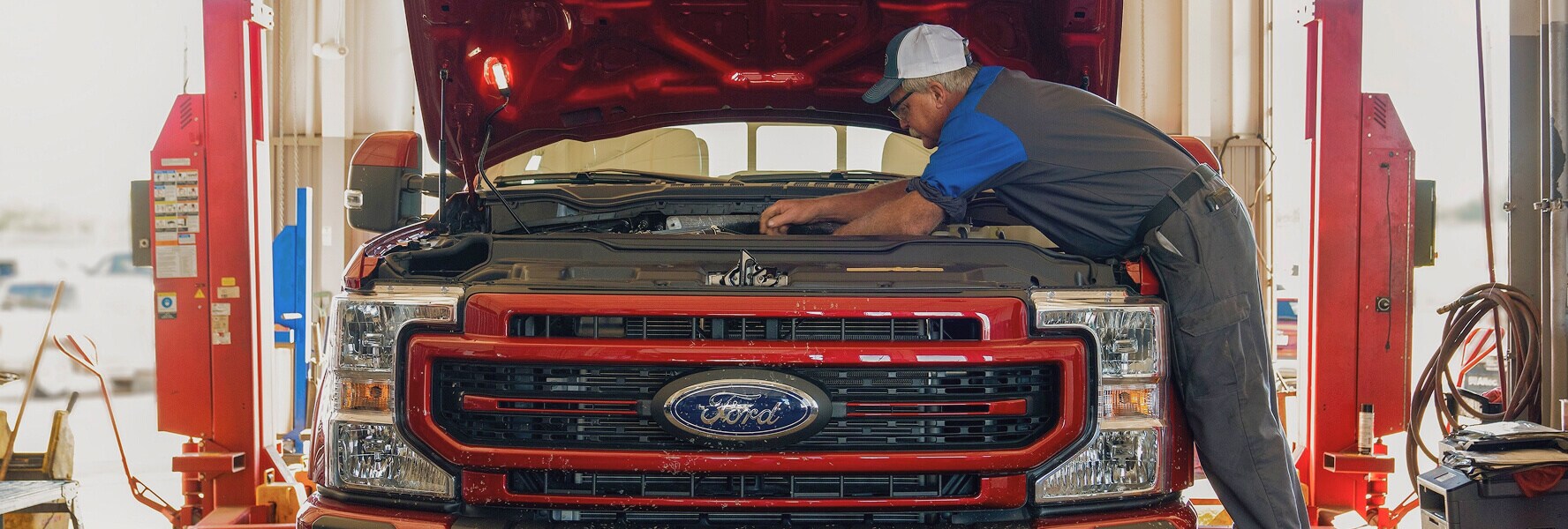 Tom Wood Ford Service Technician working under the hood of a ford vehicle