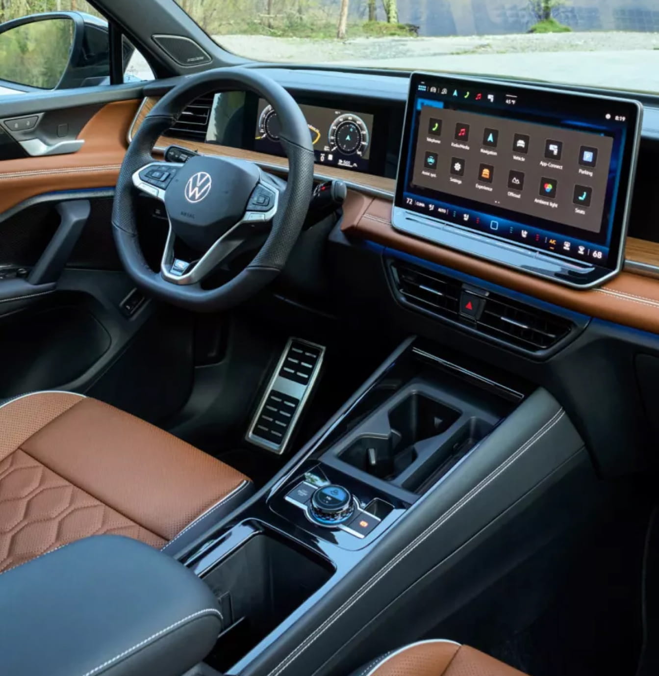 Volkswagen Tiguan interior with a sleek design featuring a leather steering wheel, digital dashboard, large touchscreen display, and brown leather seats.