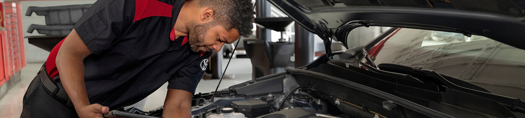 Certified automotive technician inspecting car engine