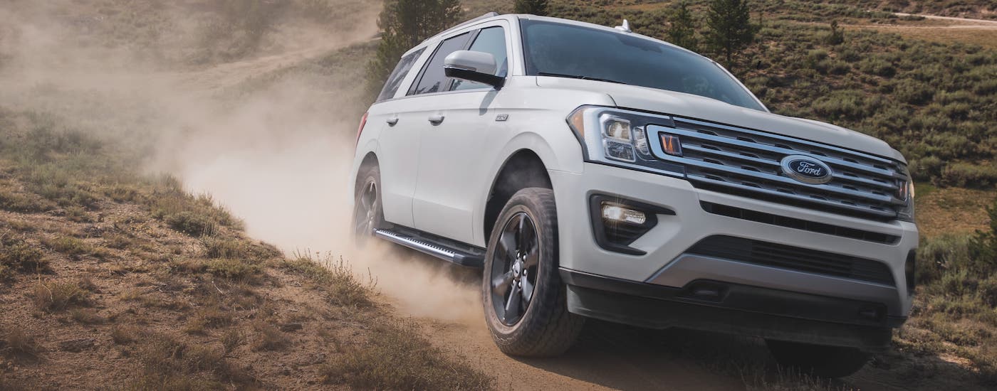 Town and Country Ford 2021 Ford Expedition XLT Dirt Road.jpg A white 2021 Ford Expedition is kicking up dirt while off-roading.