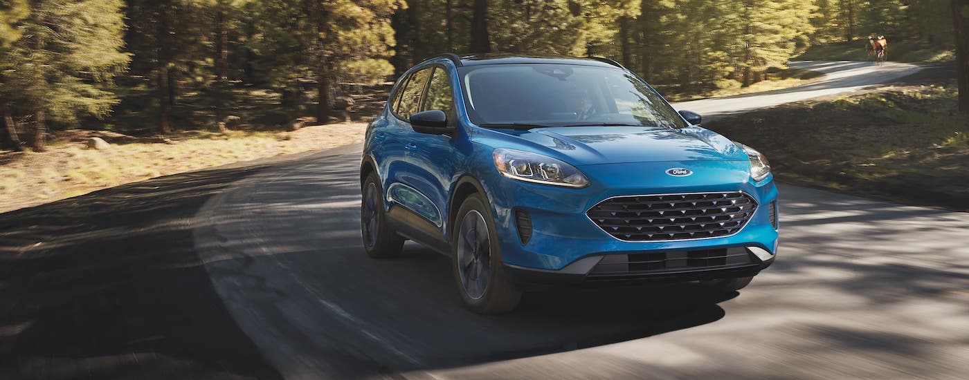 2021 Ford Escape Blue Driving.jpg A blue 2021 Ford Escape is driving on a winding road in the woods.