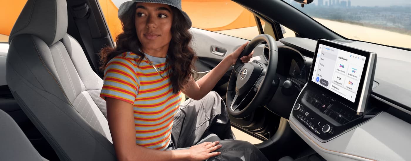 Toyota Corolla for Sale 2025 Toyota Corolla FX - Interior.jpg Woman sitting in the drivers' seat of a 2025 Toyota Corolla