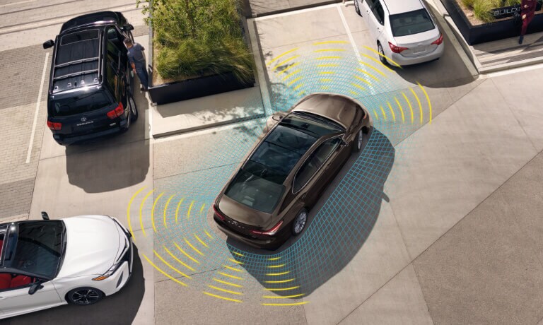 2020 Toyota Camry parking in parking lot witha visual of the saftey sensors