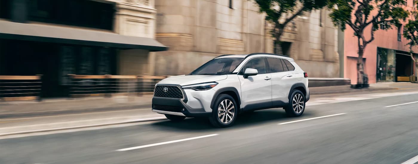 Toyota Dealer Near Me - 2023 Toyota Corolla Cross XLE - White - City Street.jpg A white 2023 Toyota Corolla Cross XLE is shown driving after leaving a Toyota dealer near you.