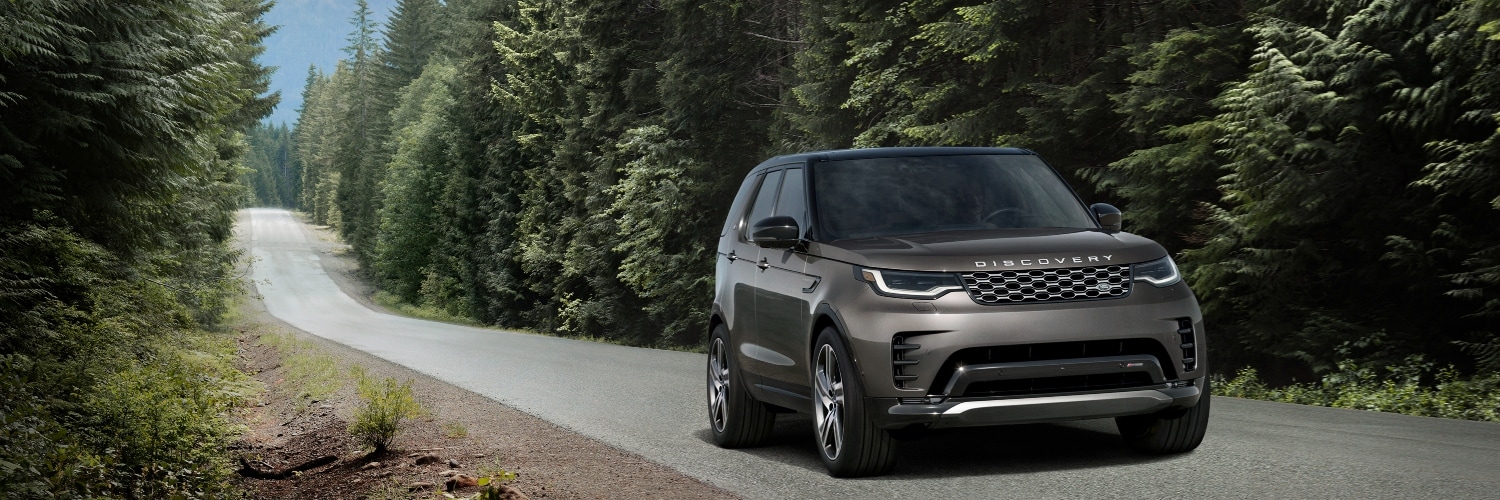 2025 Land Rover Discovery SUV Land Rover Discovery exterior driving down a road in a forest