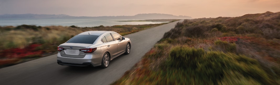 Subaru Legacy driving next to water