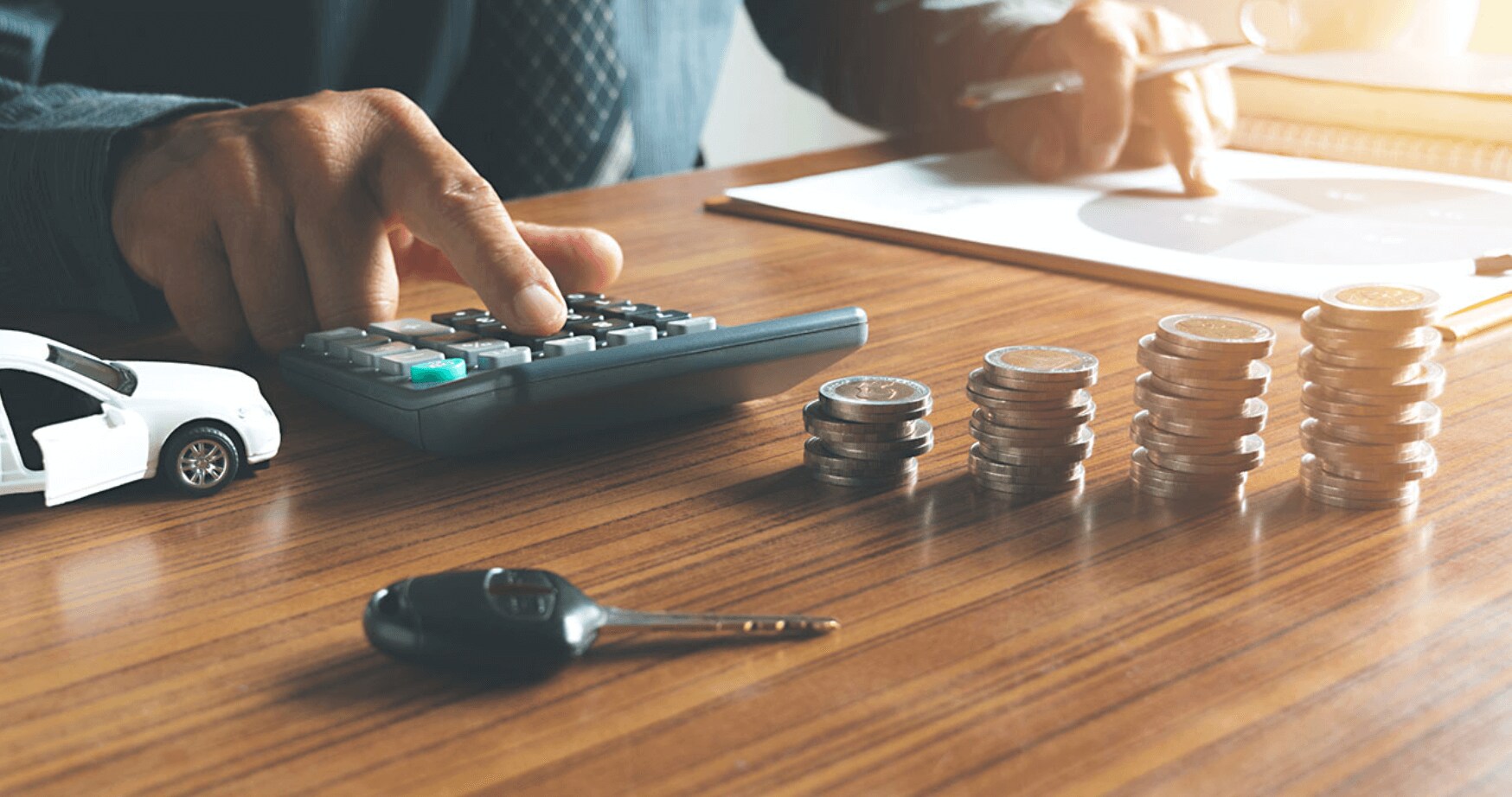 finance.png Close-up of hands using a calculator and reviewing paperwork at a dealership, illustrating Utah car sales tax calculations