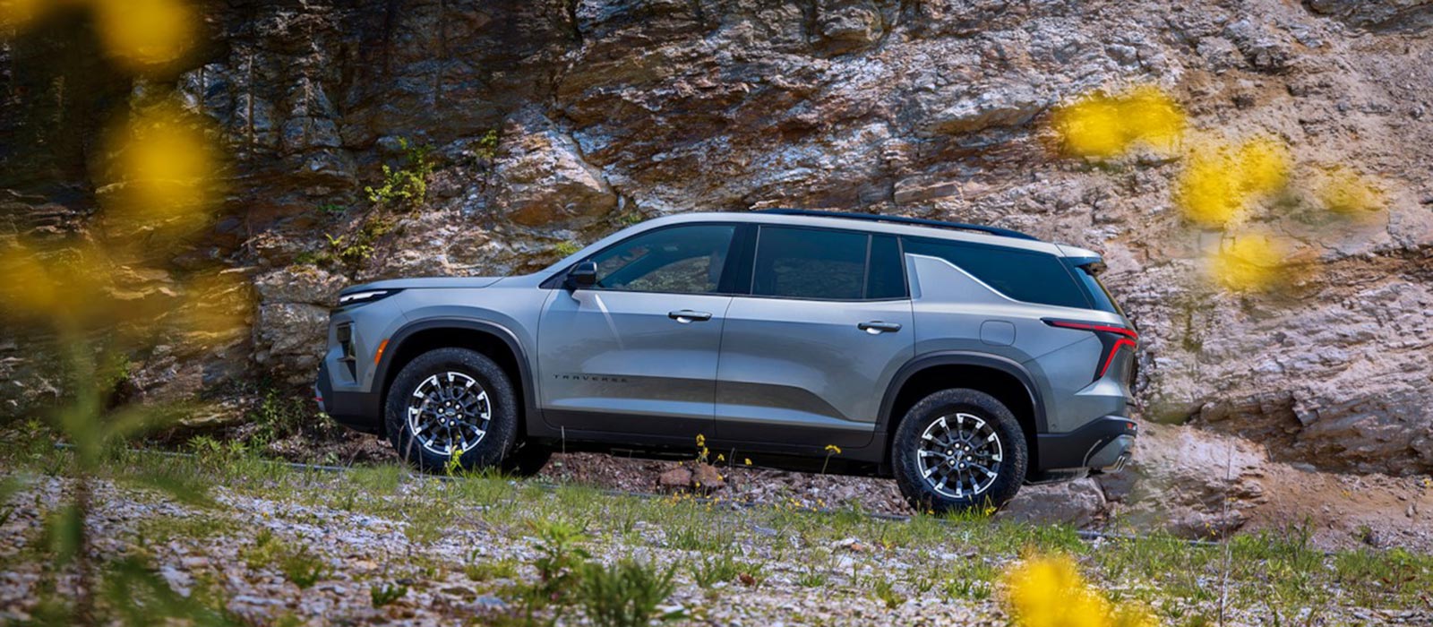 2026 Chevrolet Traverse Trim Comparison 2026 Chevrolet Traverse parked on rocky hill covered with flowers