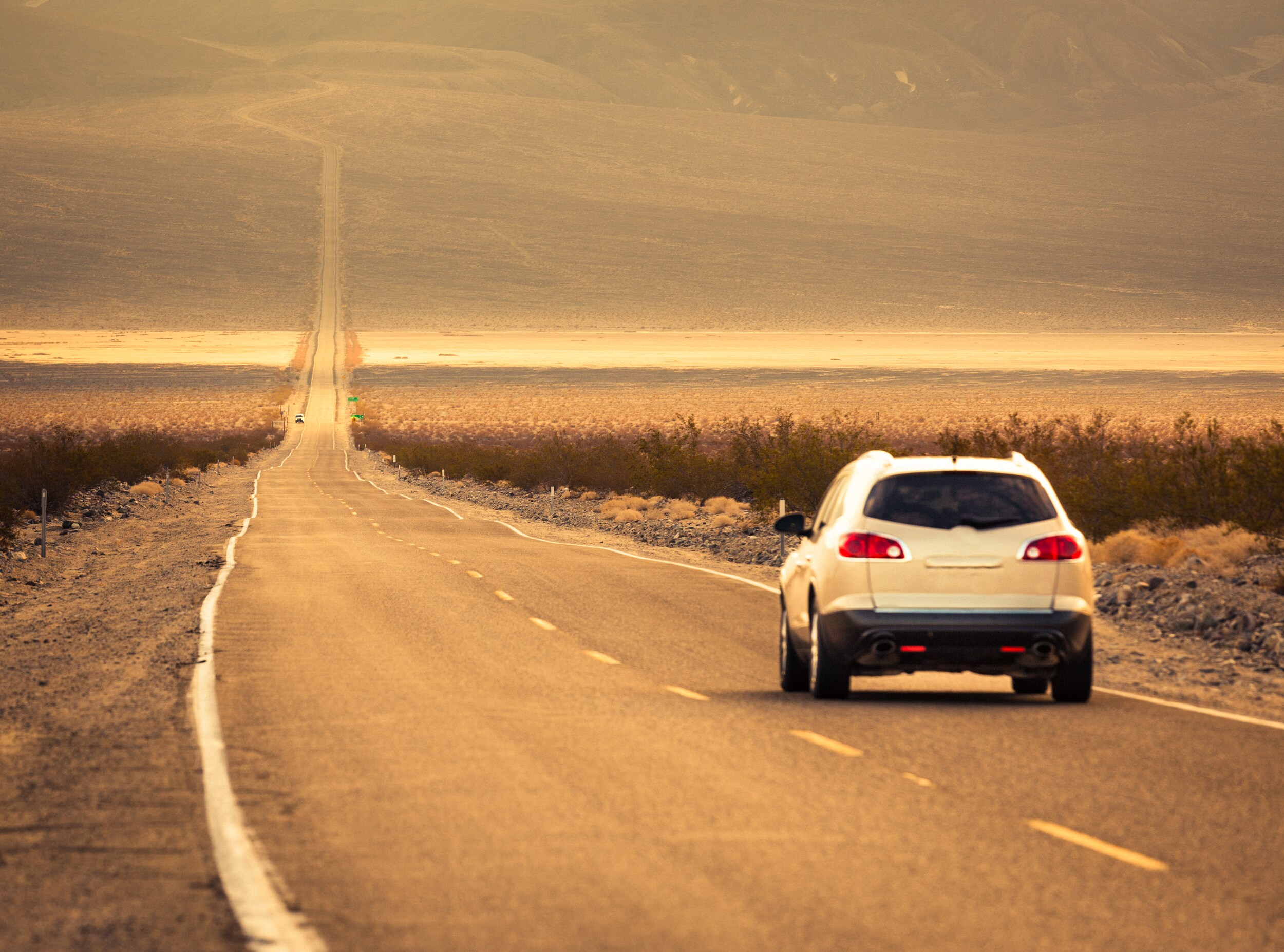 used-suvs-with-the-best-gas-mileage-phil-long-valucar-academy-dealership-colorado-springs.jpg SUV driving on long dirt road towards the mountains