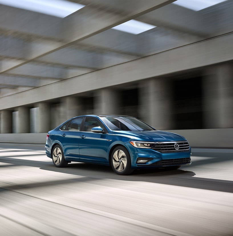 2020-Volkswagen-Jetta-SEL-Sedan-L01.png teal Volkswagen Jetta car driving through a concrete structure