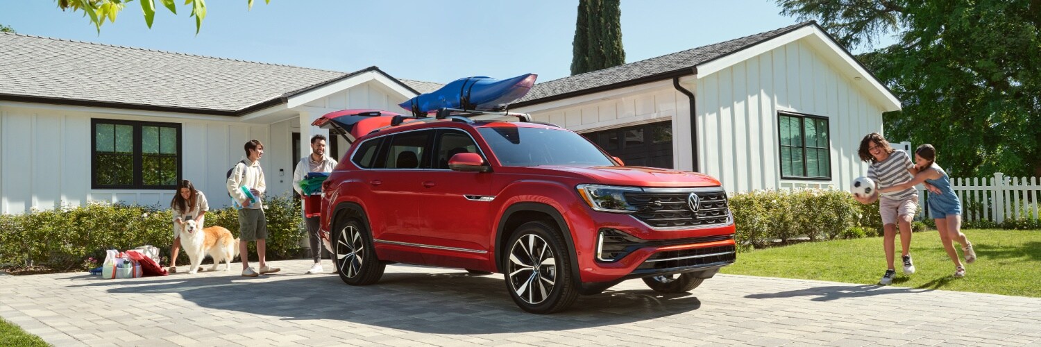 2024 Atlas red 2024 Volkswagen Atlas parked in front of a white house