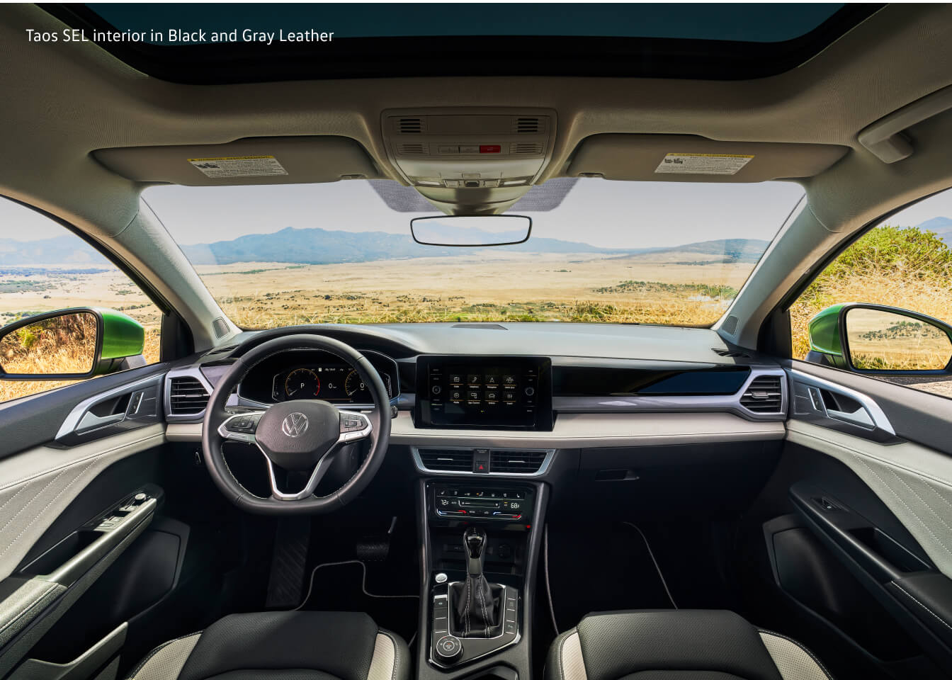 Dashboard view of a Volkswagen Taos SEL showcasing the cockpit and open sunroof.