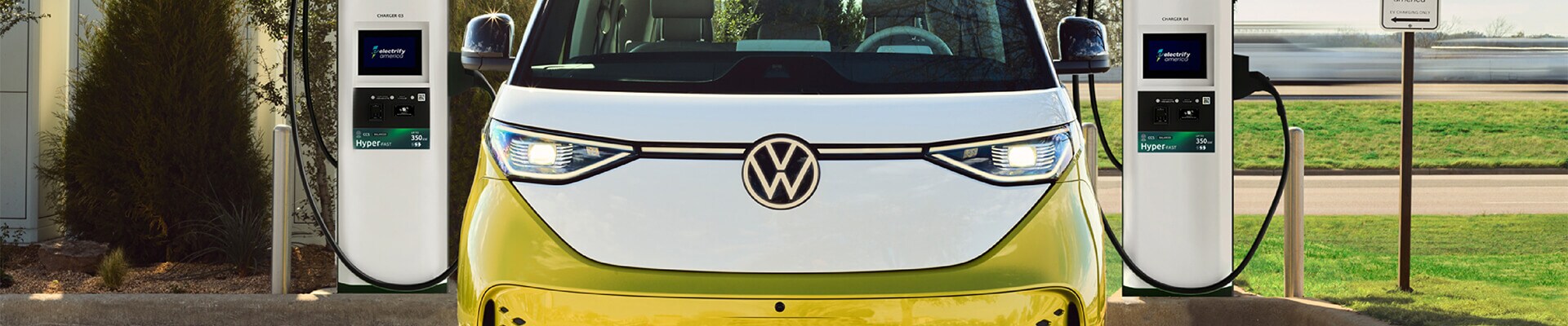 2025 Volkswagen ID. Buzz Pro S Plus shown in Pomelo Yellow Metallic & Candy White hooked up to a Electrify America Hyper-Fast Charger