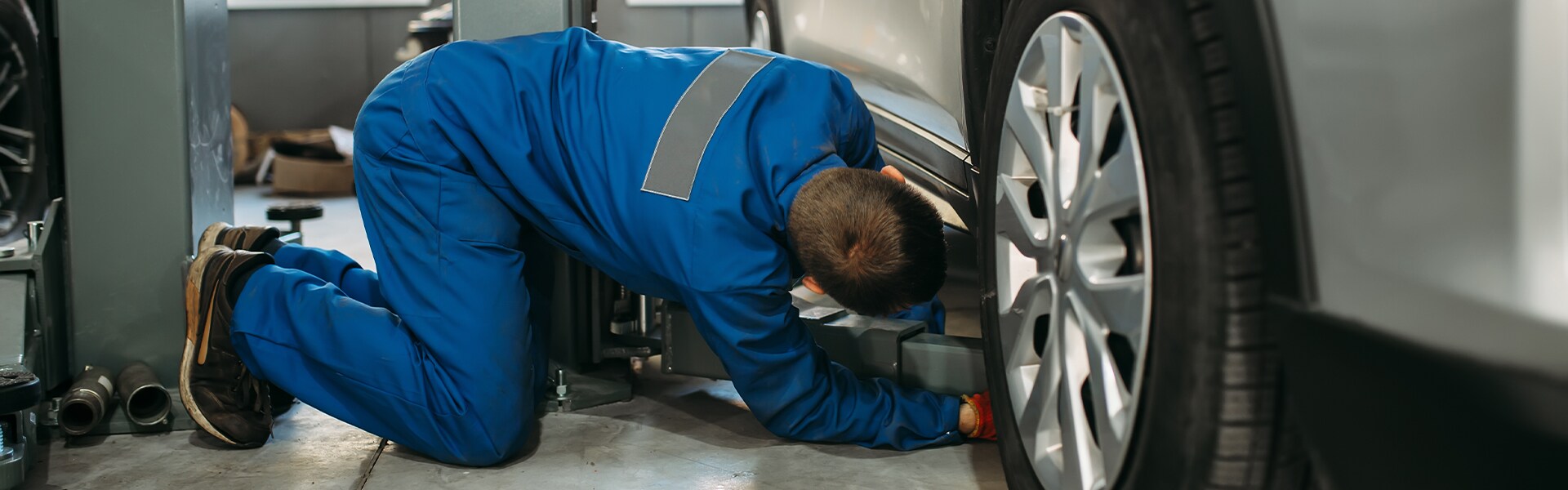 Volvo Cars New Bern is a Car Dealership near Pollocksville, NC | Service Advisor Changing Tire on Vehicle