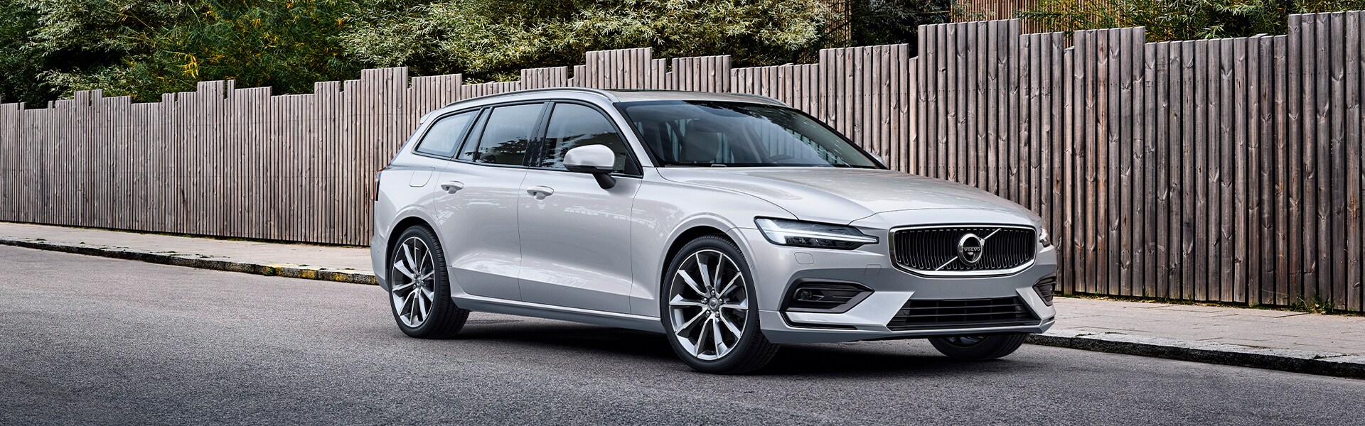Volvo Cars New Bern is a Car Dealership near River Bend NC | Silver V60 Street Parked in Front of Fence Volvo Cars New Bern is a Car Dealership near River Bend NC | Silver V60 Street Parked in Front of Fence