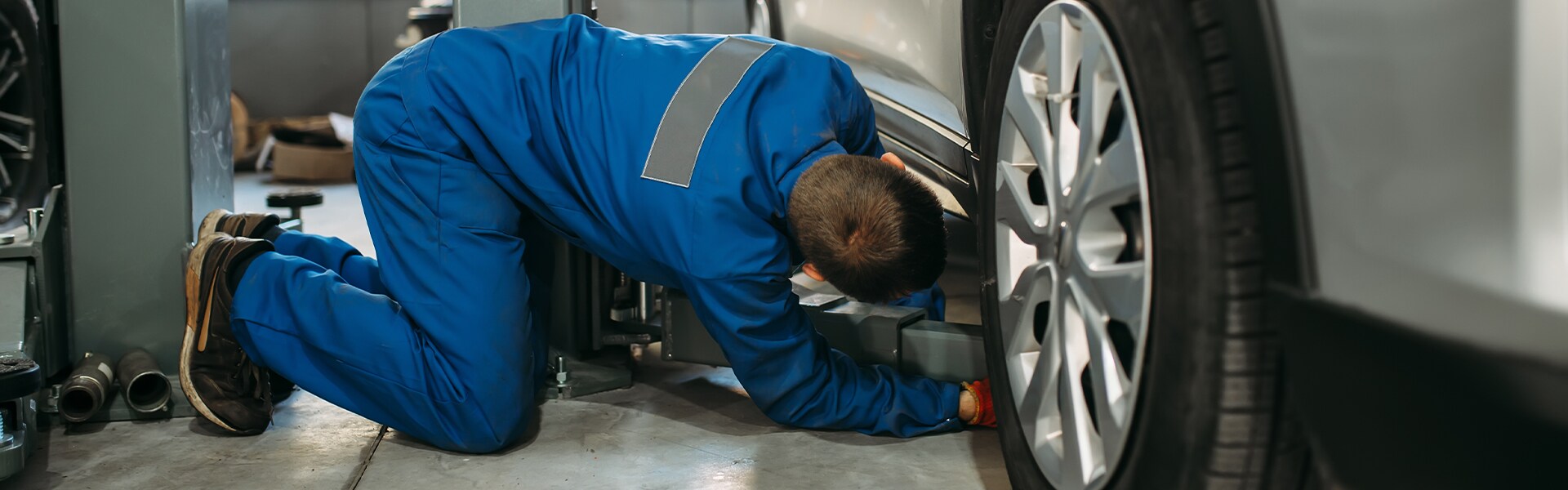 Volvo Cars New Bern is a Car Dealership near River Bend NC | Service Advisor Replacing Tire on Car Volvo Cars New Bern is a Car Dealership near River Bend NC | Service Advisor Replacing Tire on Car