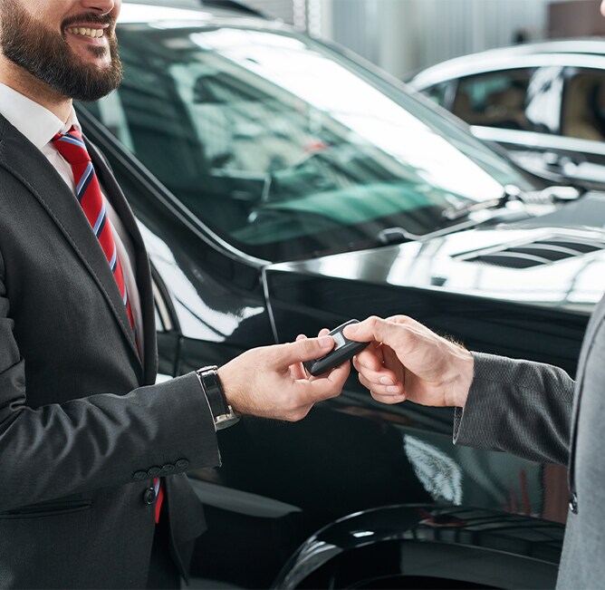 Volvo Cars New Bern is a Car Dealership near River Bend NC | Sales Advisor Passing Off Keys to New Car to Customer Volvo Cars New Bern is a Car Dealership near River Bend NC | Sales Advisor Passing Off Keys to New Car to Customer