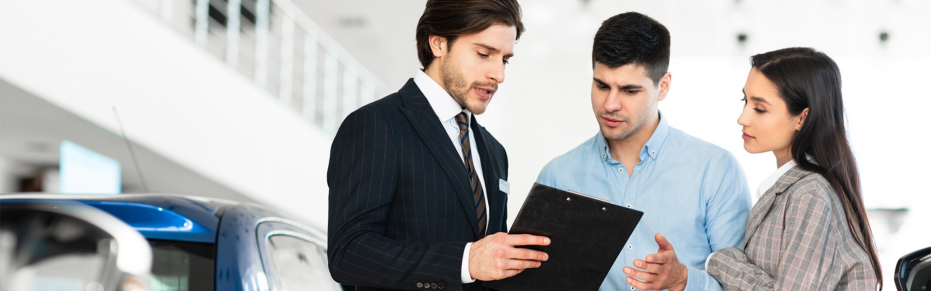 Leasing versus buying a Volvo at Volvo Cars New Bern | Couple Speaking to Sales Advisor While Standing in Dealership Leasing versus buying a Volvo at Volvo Cars New Bern | Couple Speaking to Sales Advisor While Standing in Dealership