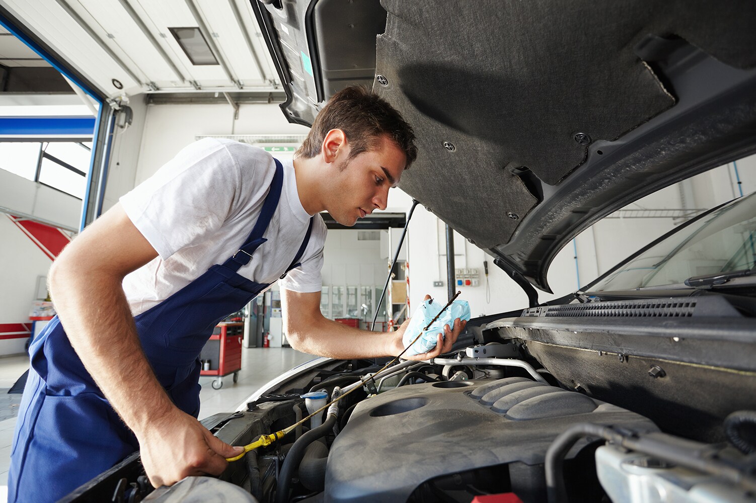 Volvo Cars New Bern is a Car Dealership near Bogue, NC | Service Advisor working under the hood of vehicle