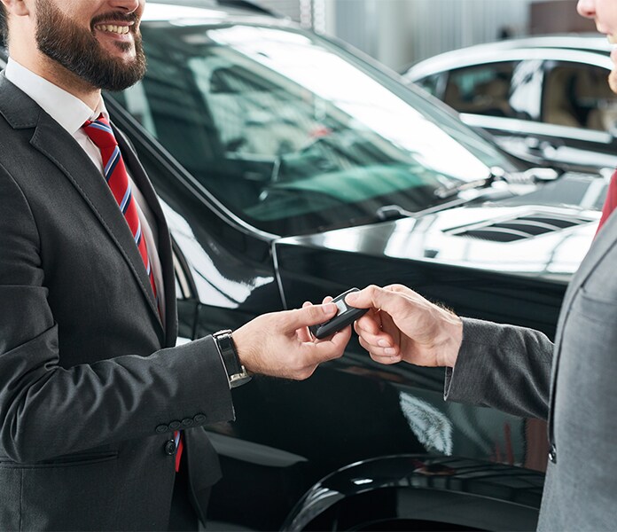 Volvo Cars New Bern is a Car Dealership near Pollocksville, NC | Sales Advisor and Customer Handing Off Keys