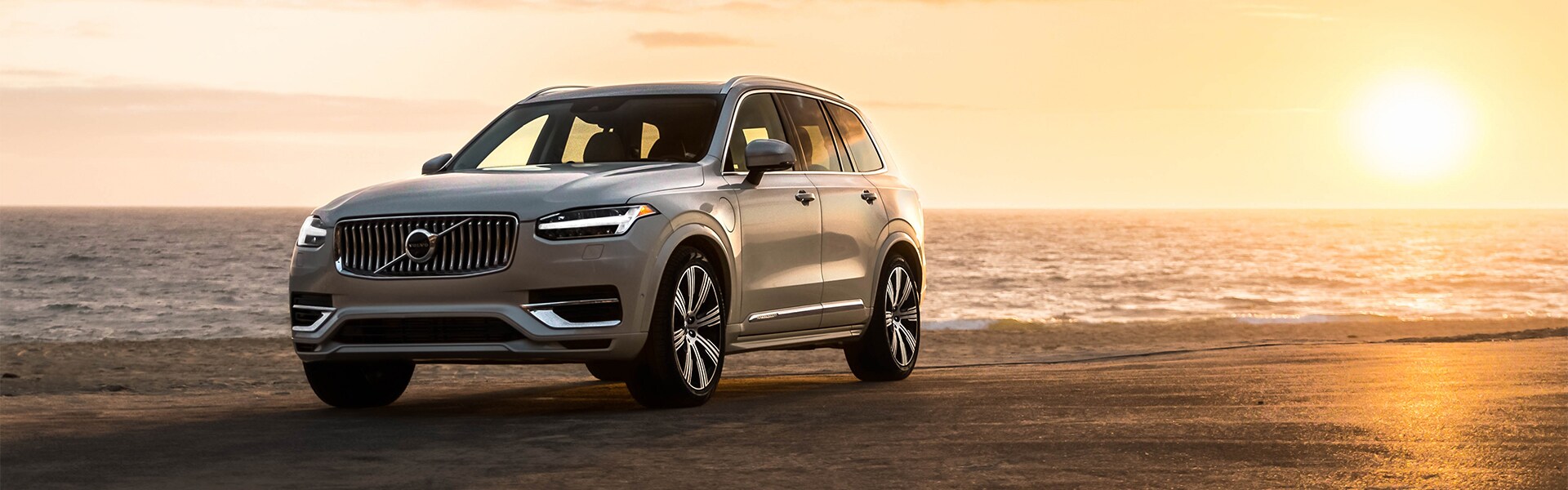 Volvo of New Bern is a Car Dealership in New Bern near Trent Woods, NC | Beige 2020 XC90 Driving on Beach at Sunset Volvo of New Bern is a Car Dealership in New Bern near Trent Woods, NC | Beige 2020 XC90 Driving on Beach at Sunset
