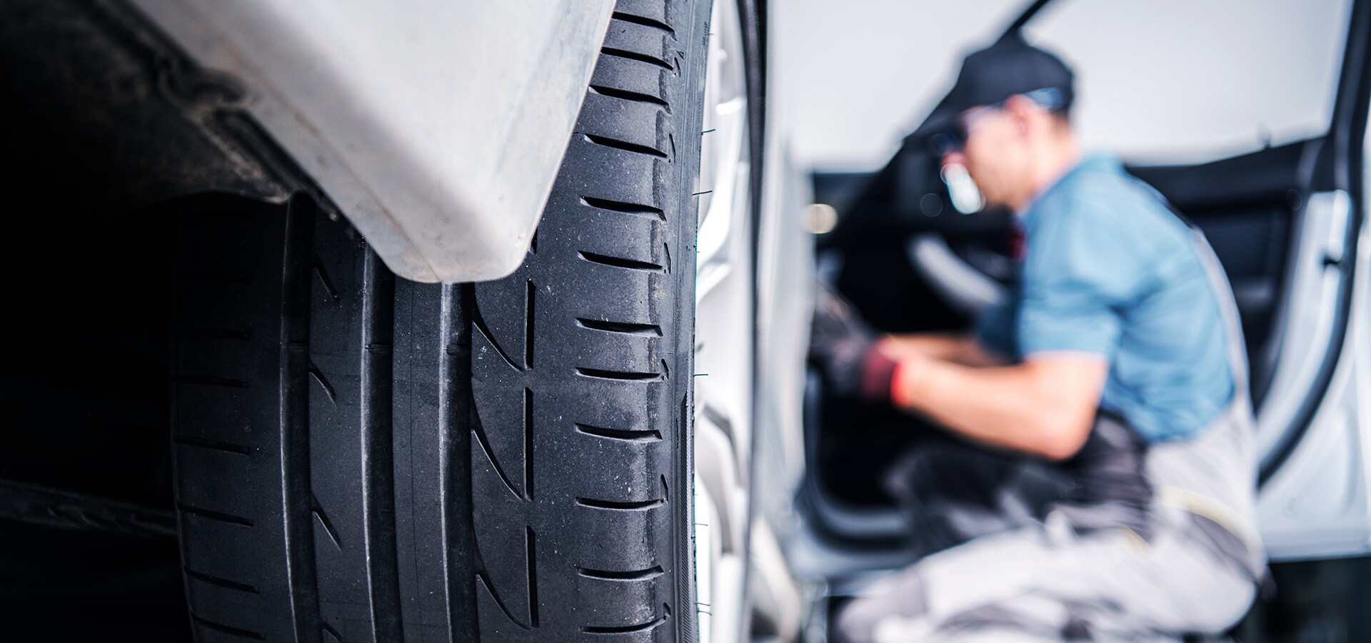 Volvo of New Bern is a Car Dealership in New Bern near Neuse Forest NC | Service Advisor Working on Vehicle Tire Volvo of New Bern is a Car Dealership in New Bern near Neuse Forest NC | Service Advisor Working on Vehicle Tire