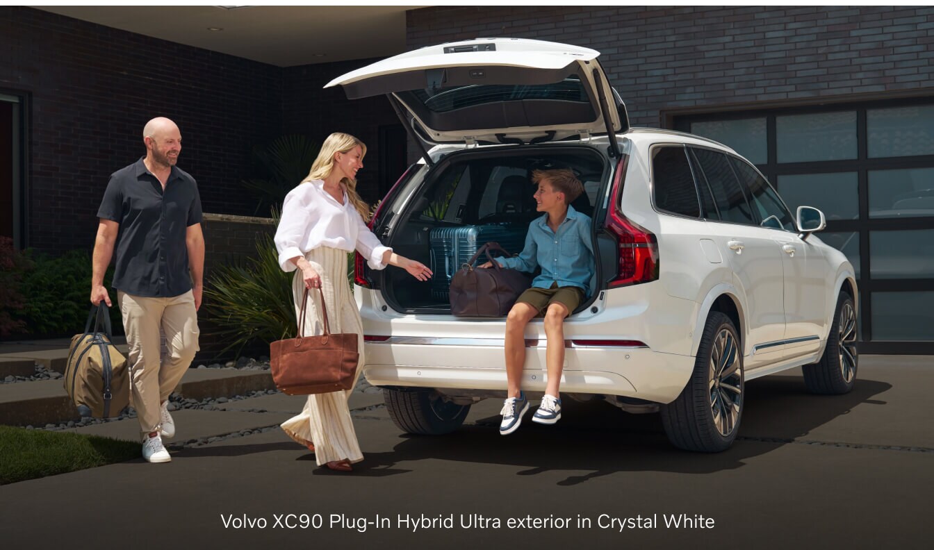 Volvo XC90 Plug-In Hybrid Ultra with an open tailgate in a modern driveway.