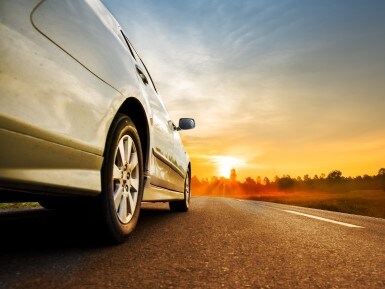 Used car on the road at sunset
