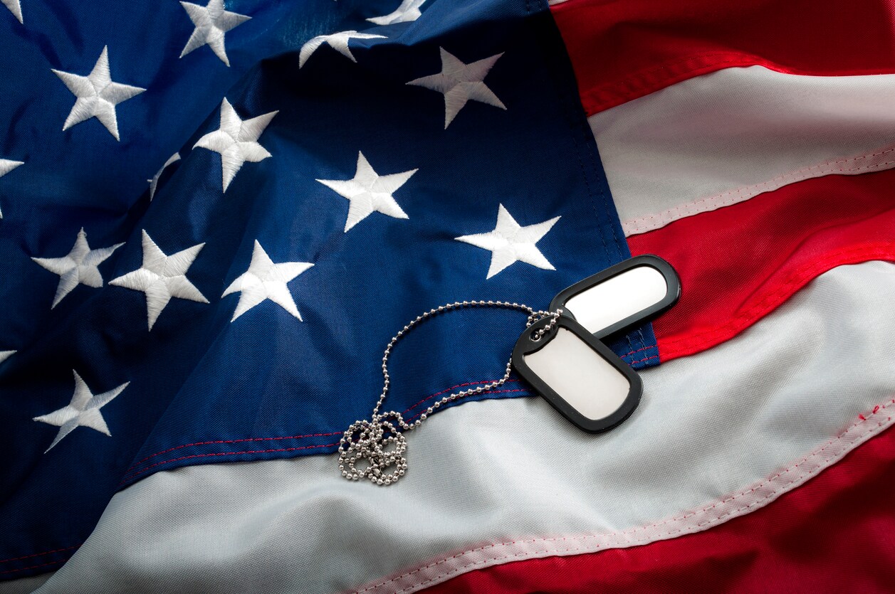Military dog tags laid across the American Flag