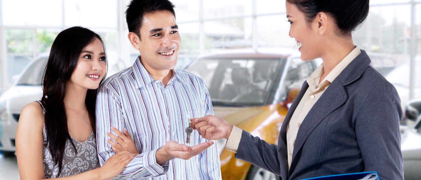 Couple being handed keys to new car