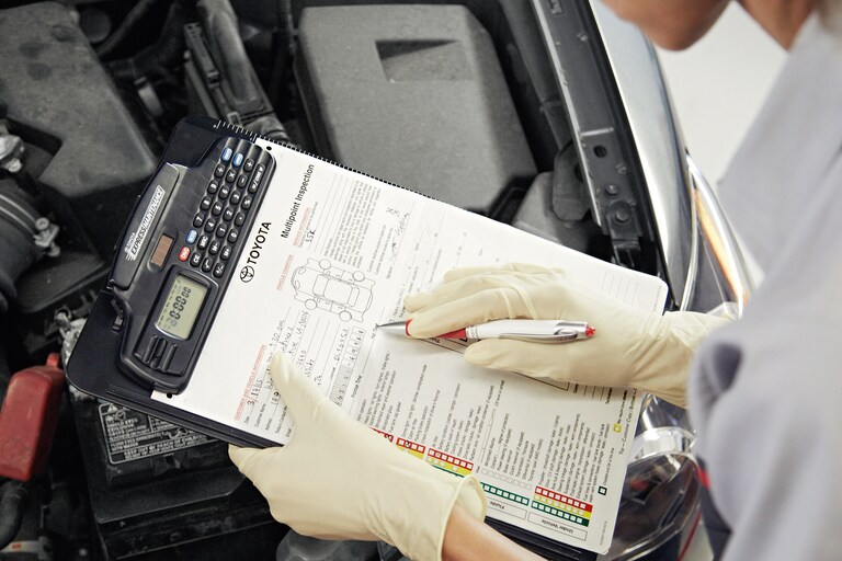 A technician holds a service clipboard and checklist