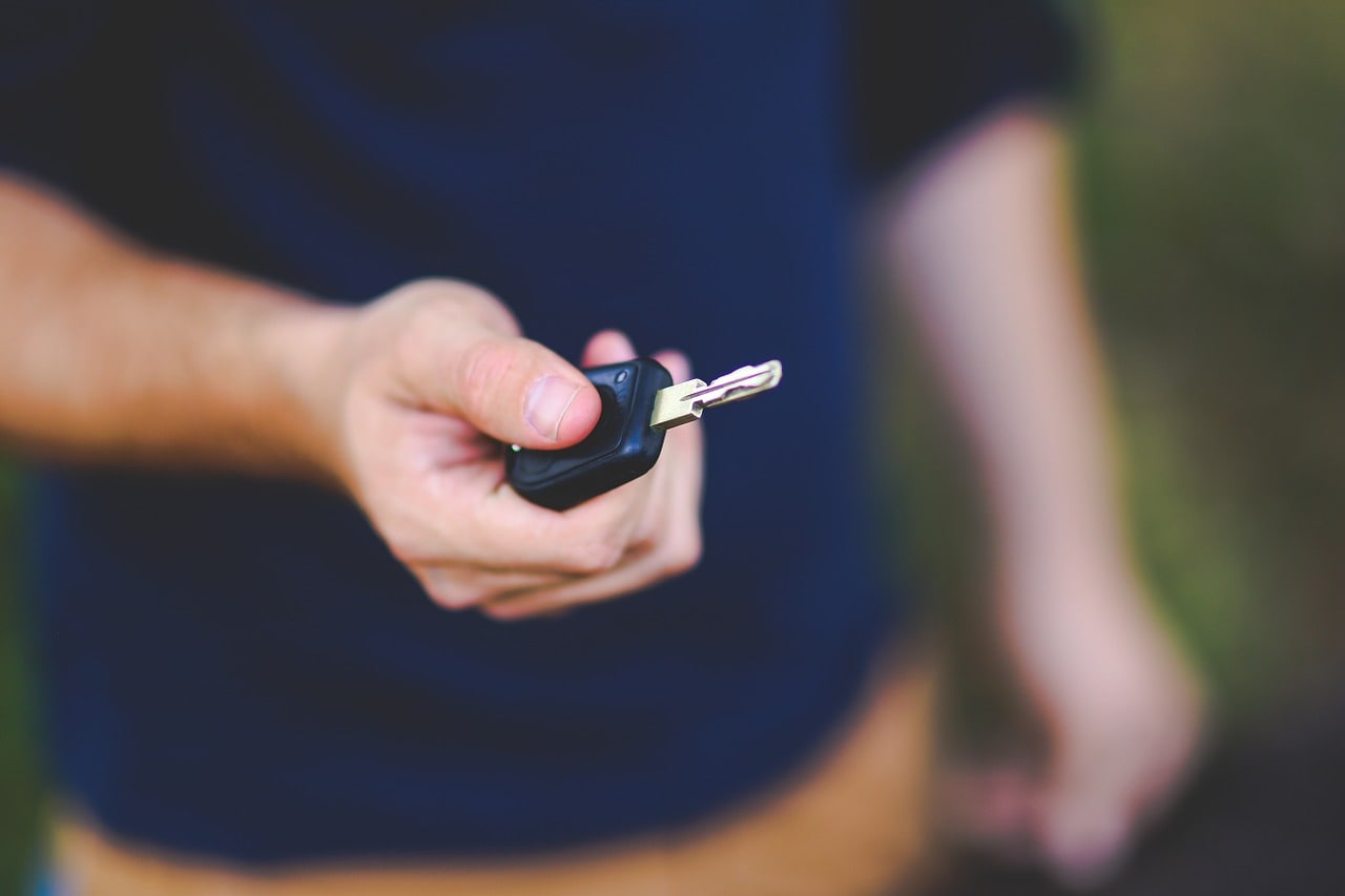 guy handing car keys handing Mitsubishi key