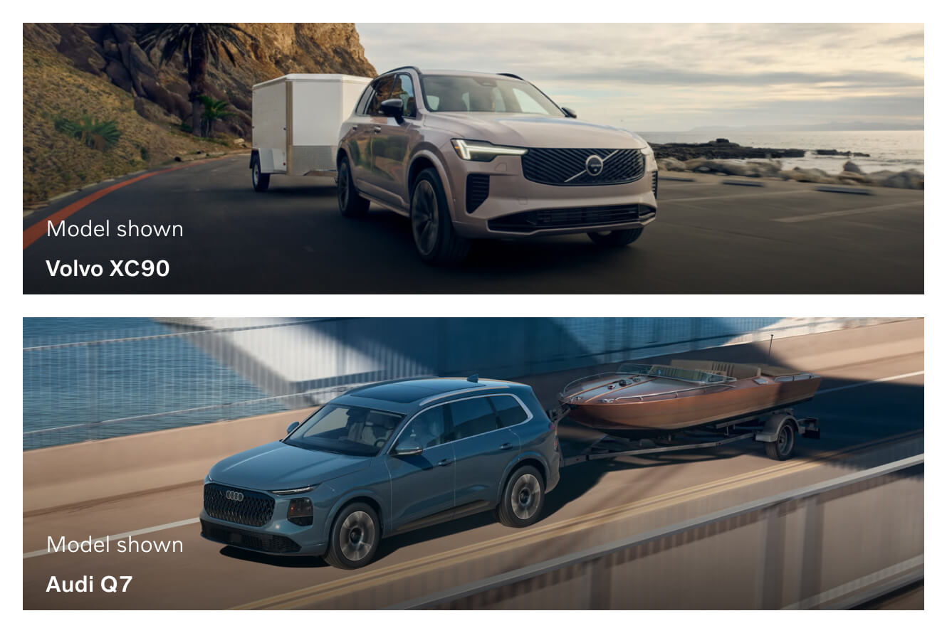 A Volvo XC90 tows a cargo trailer along a beachside road. An Audi Q7 tows a boat across a bridge.