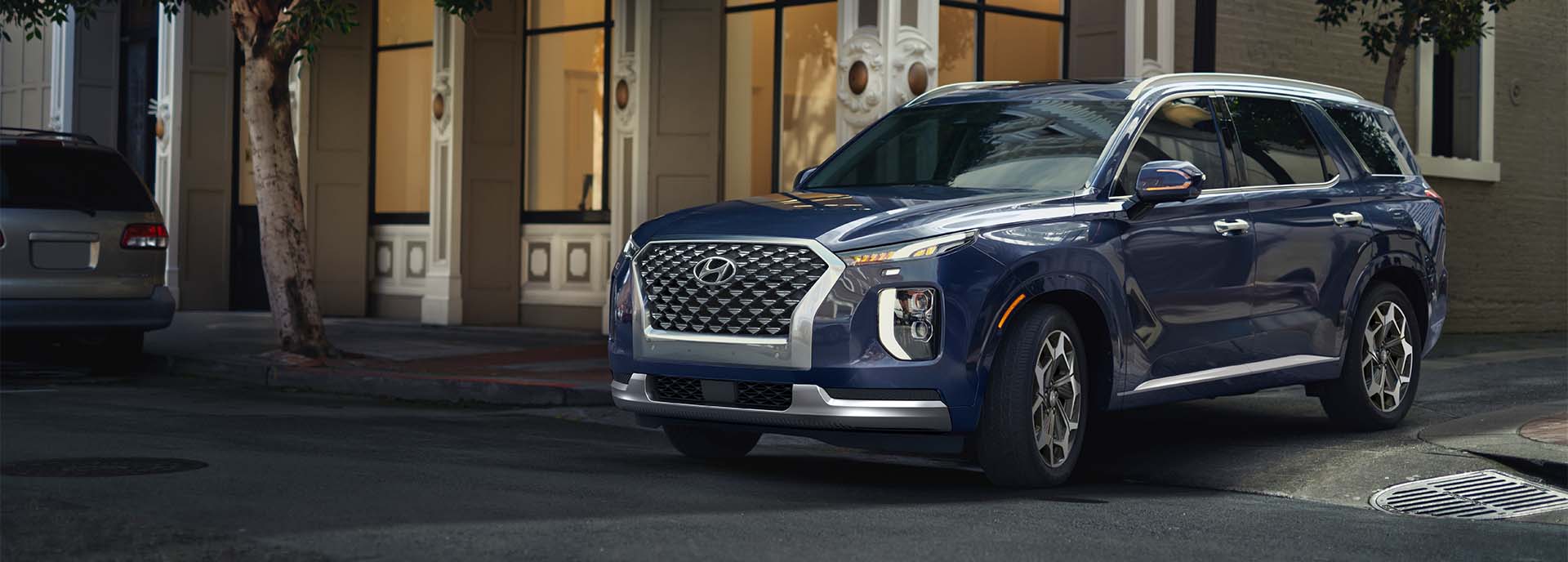 Model Features of the 2022 Hyundai Palisade at West Broad Hyundai | Blue 2022 Hyundai Palisade Pulling Out of Alley in City
