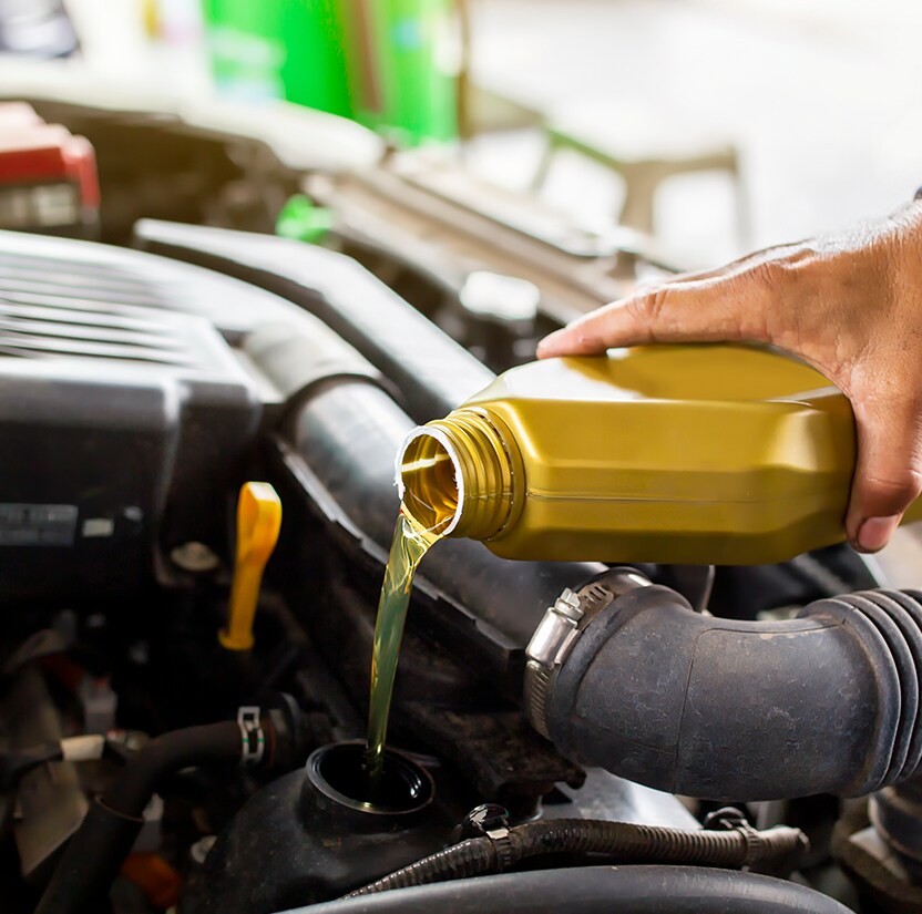 Extend the Life of Your Vehicle at West Broad Hyundai in Henrico, VA | Person's hand pouring new engine oil into his car's engine