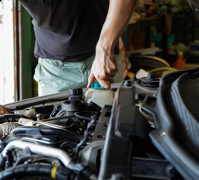 How to Get Your Car Summer Ready at West Broad Hyundai in Henrico, VA | Man in black twisting off coolant reservoir cap