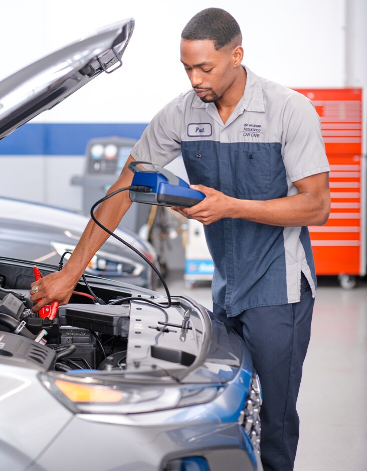 Everything You Need to Know about Your Car Battery at West Broad Hyundai | Hyundai mechanic checking the battery life of a car with car battery reader