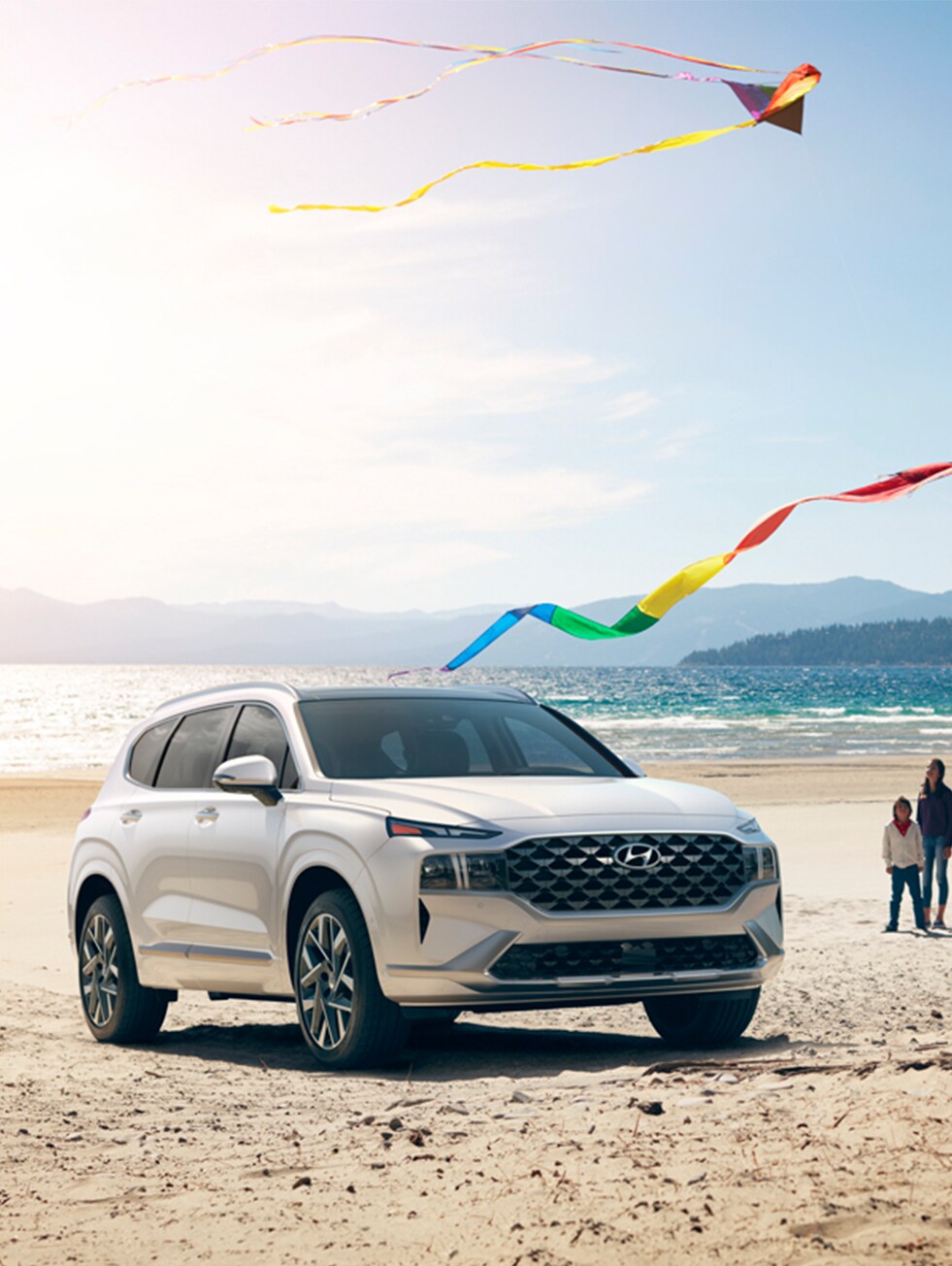 2023 Hyundai Santa Fe at West Broad Hyundai | White 2023 Santa Fe parked on beach sand with the ocean in the background