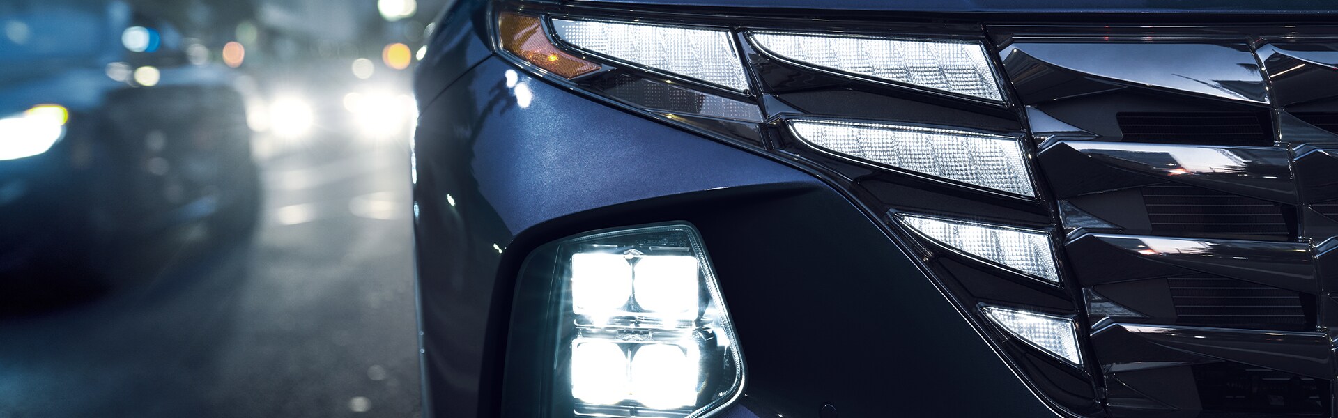 Performance features of the 2022 Tucson Hybrid at West Broad Hyundai of Henrico | Close up of the 2022 Hyundai Tucson headlight while powered on