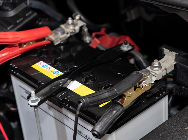 Everything You Need to Know about Your Car Battery at West Broad Hyundai | Close up of battery jumper cables on battery terminal