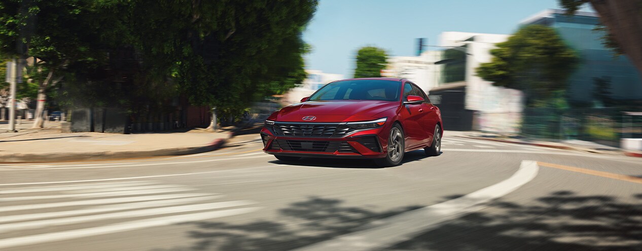2025 Hyundai Elantra at West Broad Hyundai | Red 2025 Hyundai Elantra driving down a city street